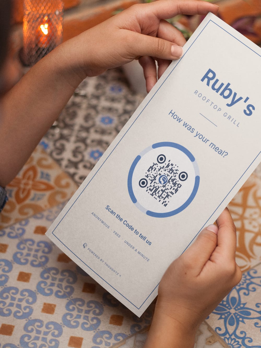 A restaurant menu on a set table, a Thoughtz Code printed on the front.